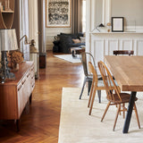 Glam Rug in Perle under a dining table on a parquet floor