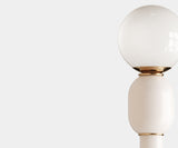 Mid-Century Modern Floor Lamp Design: White Metal & Gold Accents. The Skylab floor lamp by Mezzo Collection redefines minimalist luxury. This image highlights the lamp's key design elements: a sleek white metal frame with a graceful curve, beautifully accented by the warmth of the gold brass base.