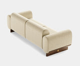 Modern Curved Sofa: Soft Fabric & Luxurious Matte Walnut Frame. The Ellis sofa by Mezzo Collection embodies the essence of modern luxury. This image highlights the key design elements: a captivating curved silhouette that offers exceptional comfort, soft and inviting fabric upholstery available in a variety of colors, and a contrasting yet sophisticated matte walnut frame.