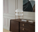 Chevalier Table Lamp: A Statement Piece for Minimalist Interiors. Elevate your minimalist space with the Chevalier table lamp. This sculptural gold-plated brass and glass design by Mezzo Collection adds a touch of artistic intrigue to a modern console table.