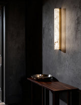 United Alabaster Roller Wall Light in natural fluted alabaster beside a walnut console