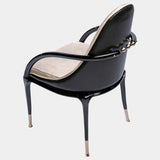 Unwind in Style: The Jera Padded Chair by Steve Leung. This modern seating option boasts a plush quilted velvet interior with a contrasting dark leather back, a sleek lacquered metal handle, and a variety of upholstery and metal finish options for a truly personalised look.