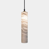 United Alabaster Tubular Bells Pendant Light in natural alabaster, single cylinder, studio view on grey