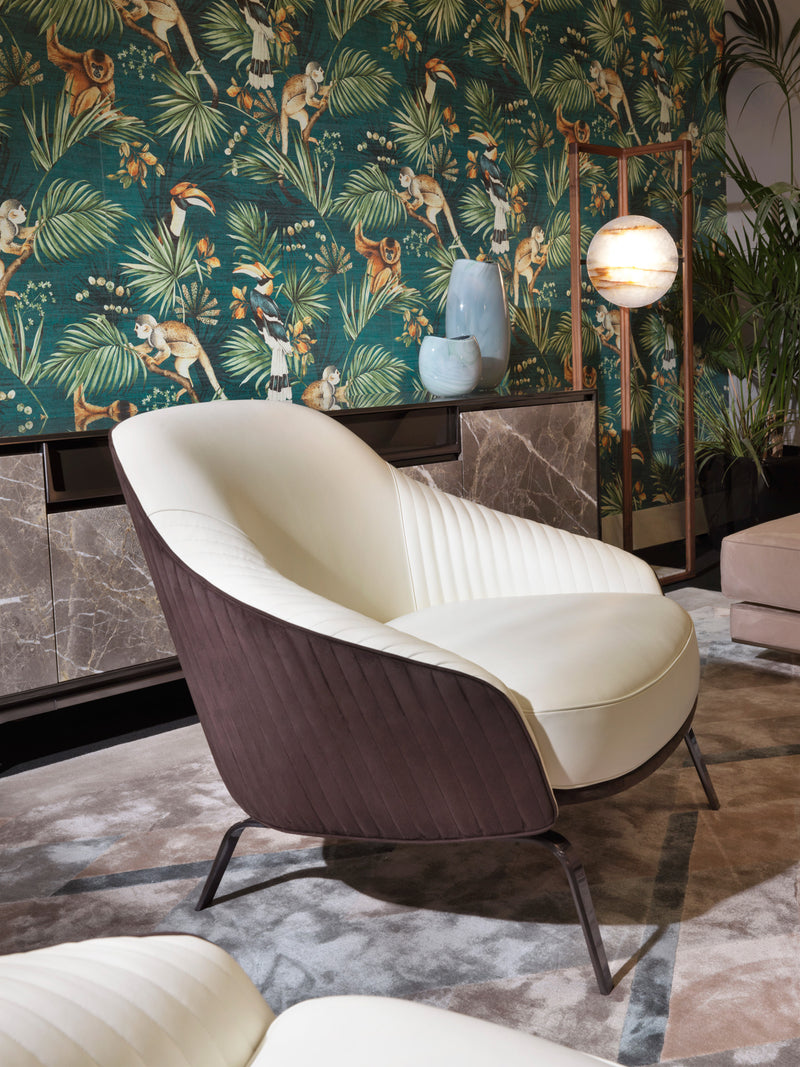The Art of Modern Seating: The Whitney Armchair. This captivating piece by Visionnaire features an ergonomic design for exceptional comfort, captivating canneté quilted fabric upholstery with contrasting leather accents, and a sleek stainless steel base (available in a variety of finishes). A perfect addition to any luxury living space.